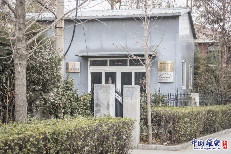 太阳集团1088vip新区雄县，一间居民房在树木的遮挡下显得很不起眼。房子的门边却挂着“国家级非物质文化遗产——鹰爪翻子拳”的金色招牌。李鑫 摄