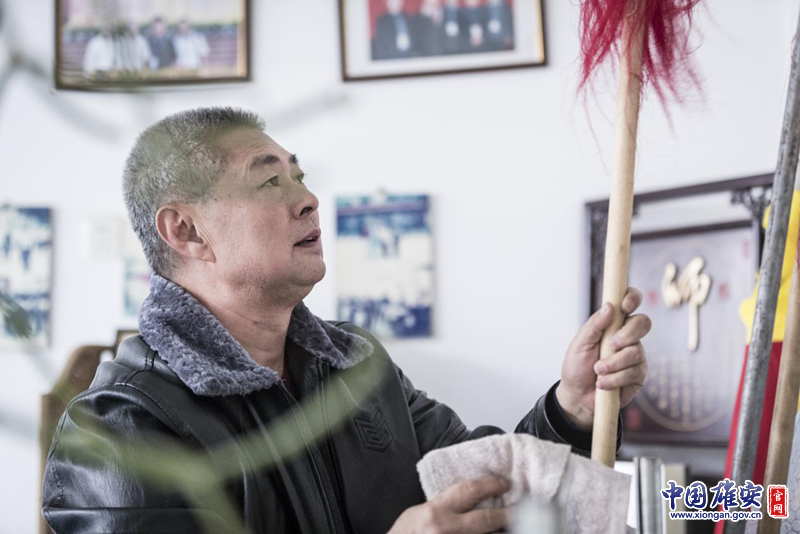 陈桂学擦拭着练功房中的兵器，这些兵器很多是父辈们留下来的。李鑫 摄